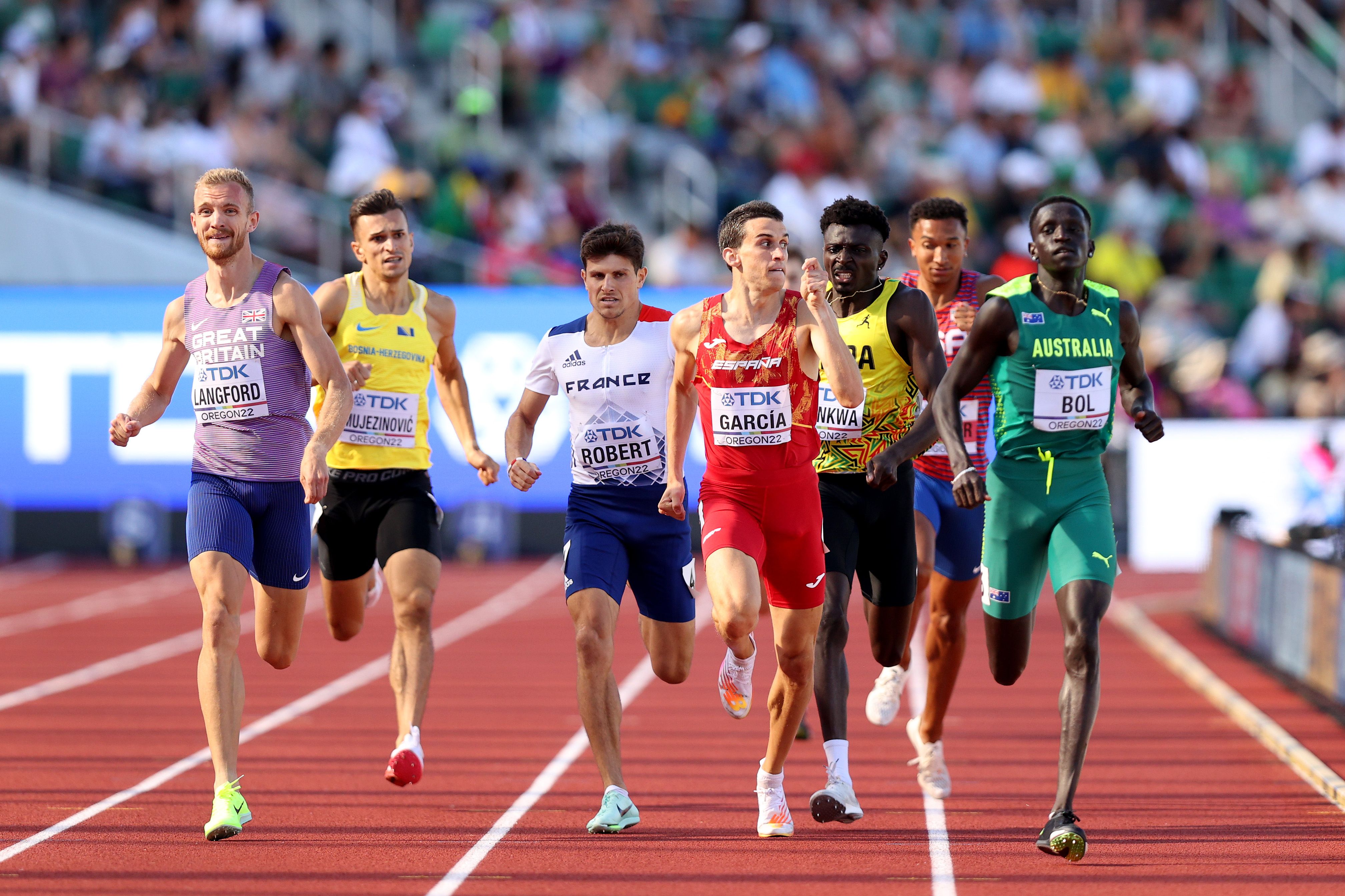 Siete Atletas de diferentes nacionalidades compitiendo en la pista de Atletismo 