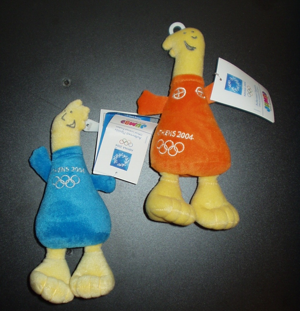 Dos peluches de los juegos Olímpicos representados por dos niños, uno vestido de color naranja y otro vestido de color azul